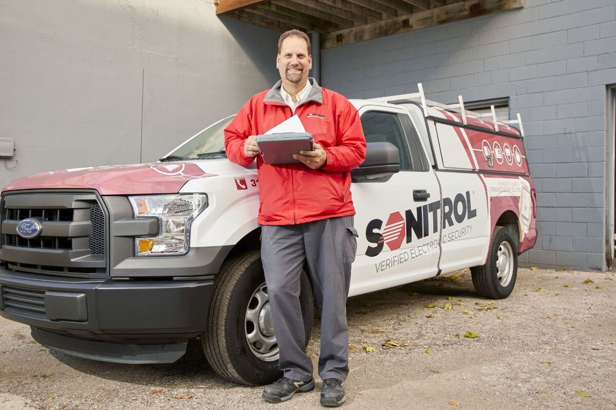 Sonitrol Technician standing with truck