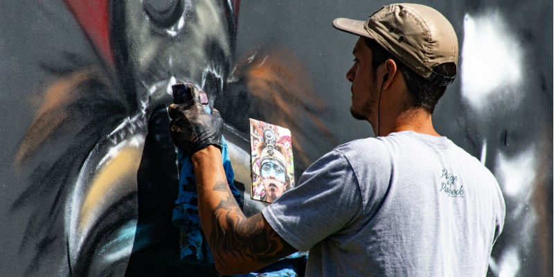 A vandal spray painting a wall