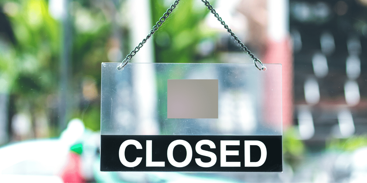 Sign saying closed on a businesses door
