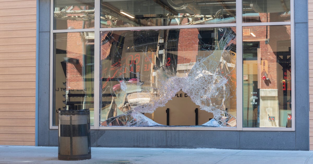 Shattered storefront window from a retail store break-in at night